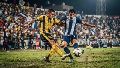 Partido entre Comerciantes Unidos y Alianza Lima con disputa intensa del balón en un estadio lleno.